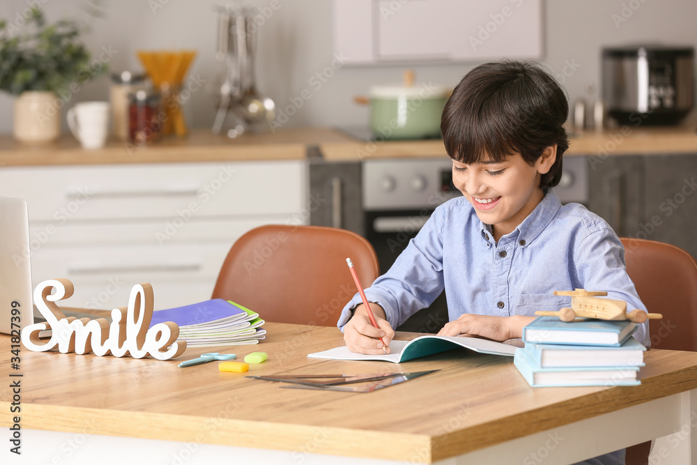 Little boy doing homework in kitchen