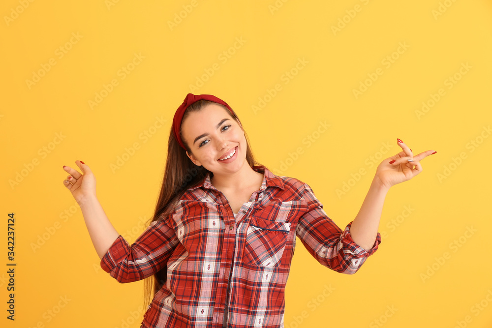 Portrait of dancing young woman on color background