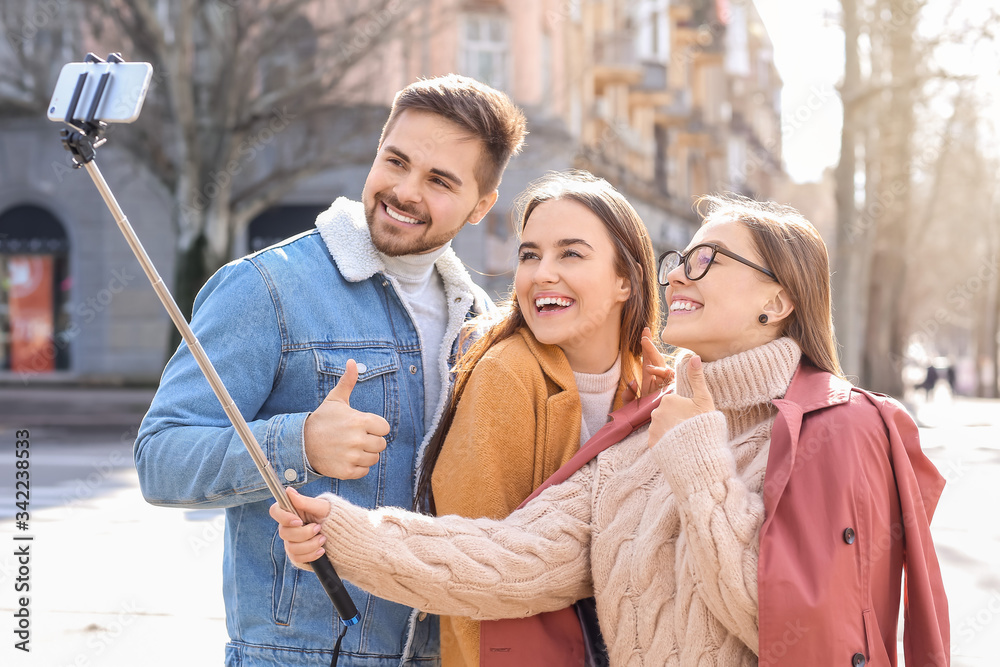 Happy friends taking selfie outdoors