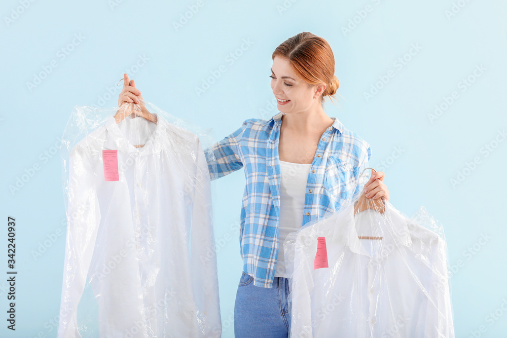 Worker of modern dry-cleaners on color background