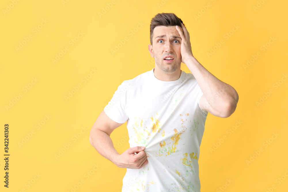 Troubled man in dirty clothes on color background