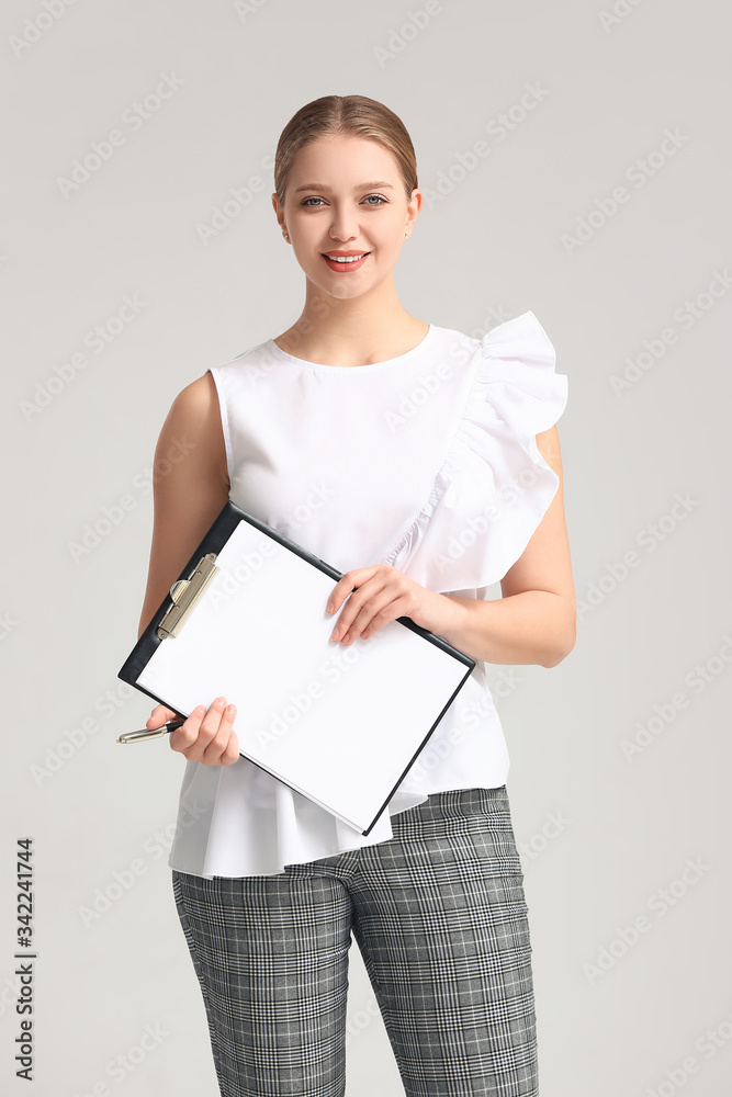 Portrait of young businesswoman on grey background