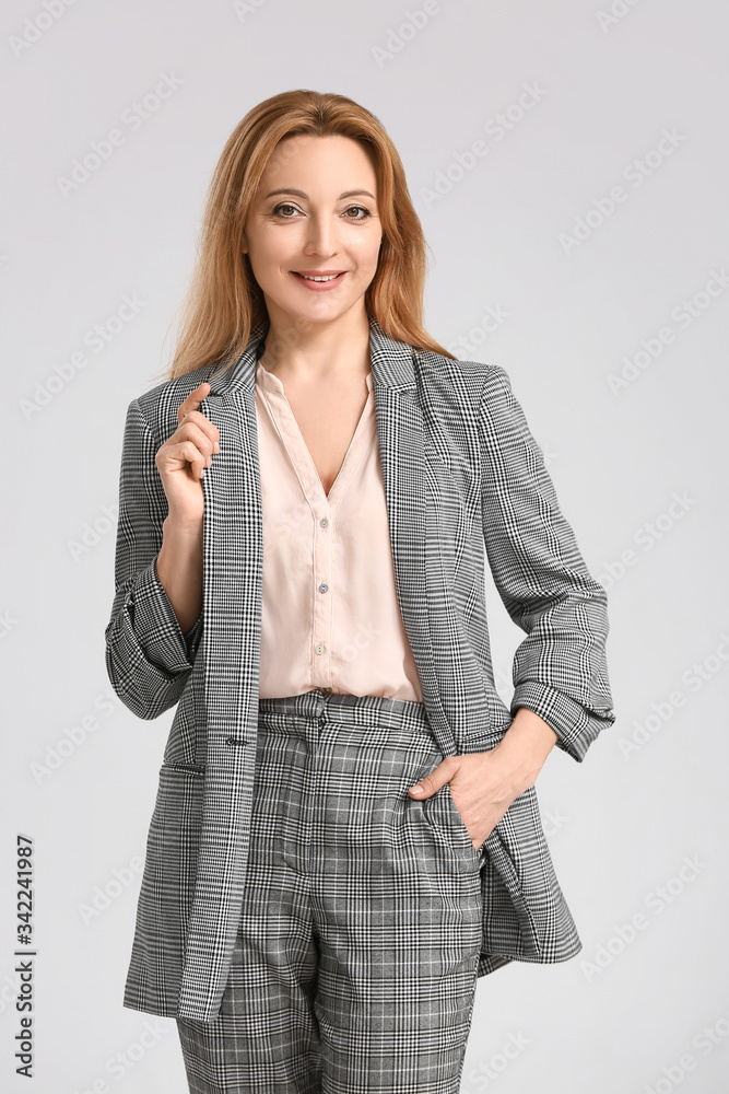 Portrait of stylish businesswoman on light background