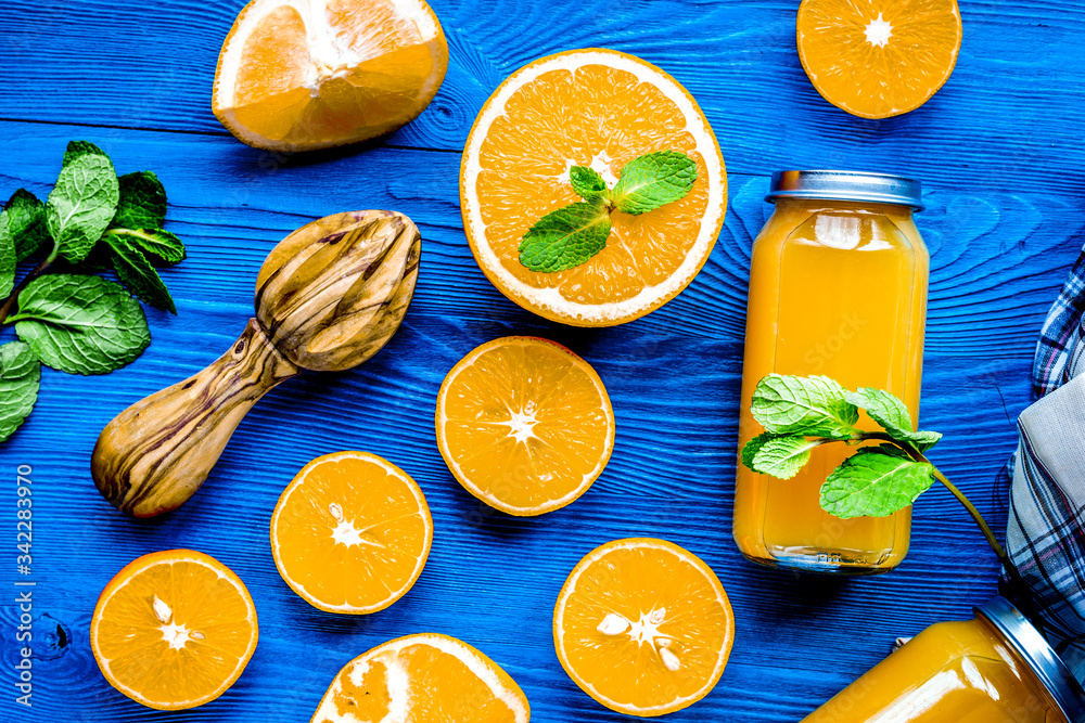 Orange juice in bottle with slices and mint on table top view