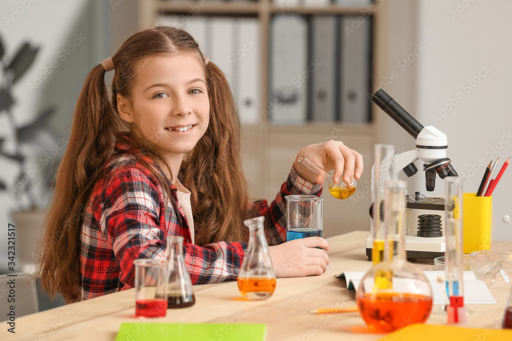 Cute little girl at chemistry lesson in classroom