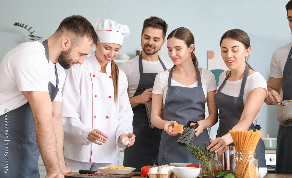 Female chef and group of young people during cooking classes