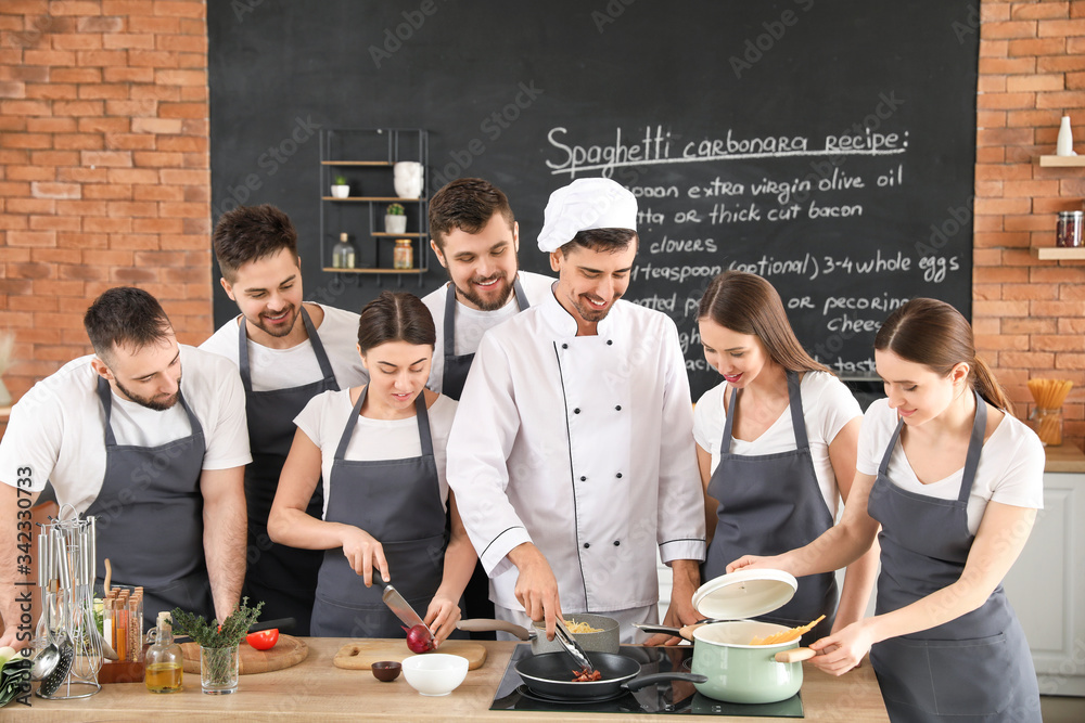 Male chef and group of young people during cooking classes