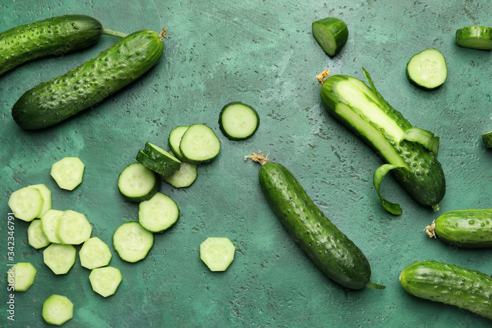 Green cucumbers on color background