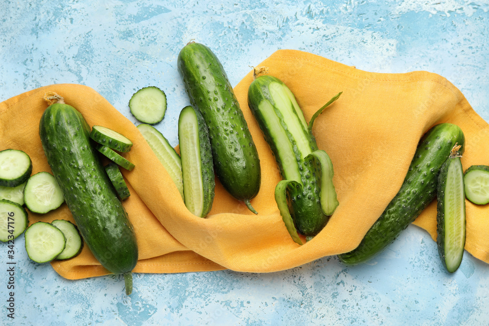 Green cucumbers on color background