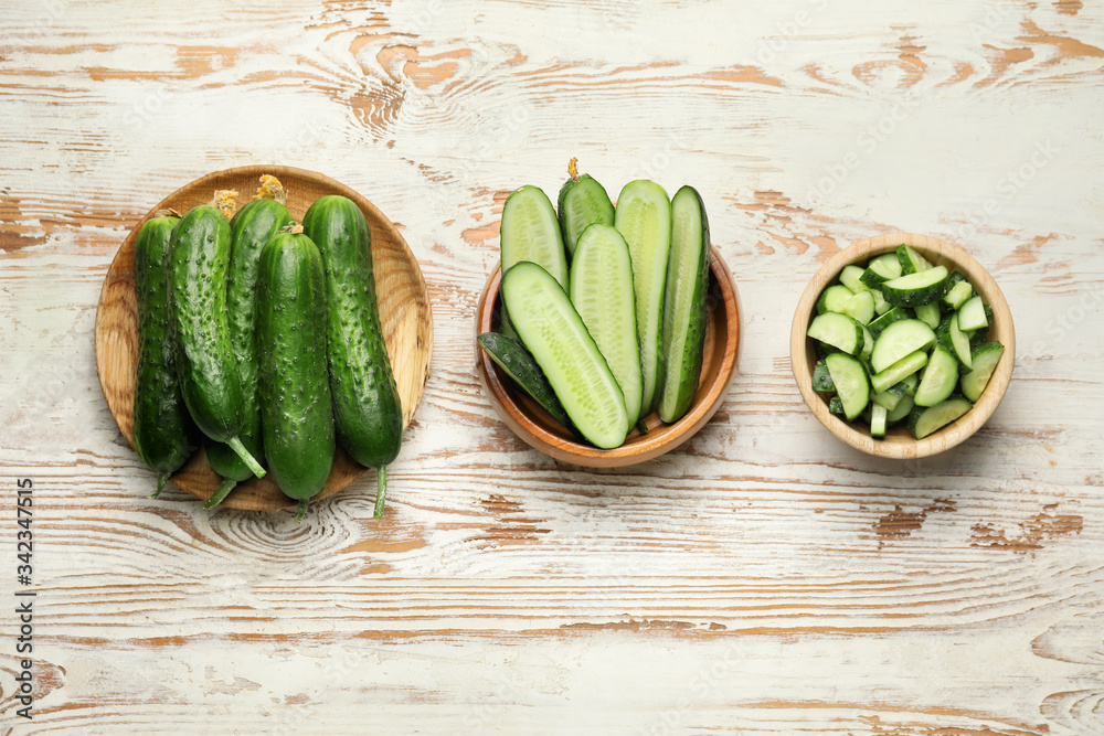 Plates with green cucumbers on wooden background