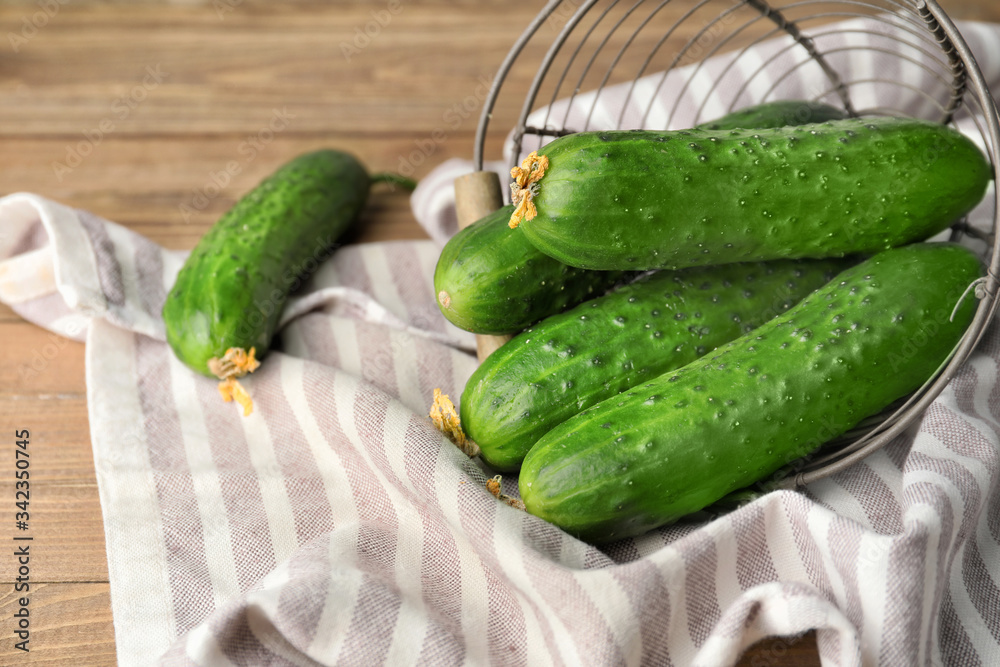 Basket with green cucumbers on wooden table