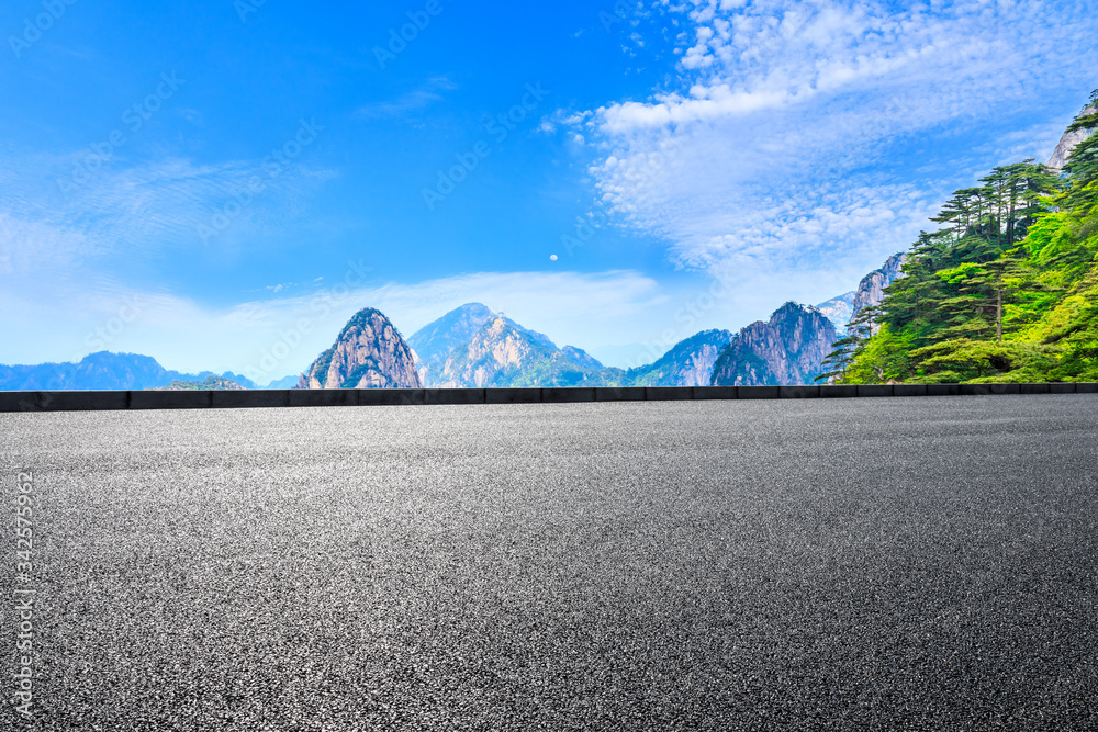 空旷的柏油路和青山，云雾缭绕。