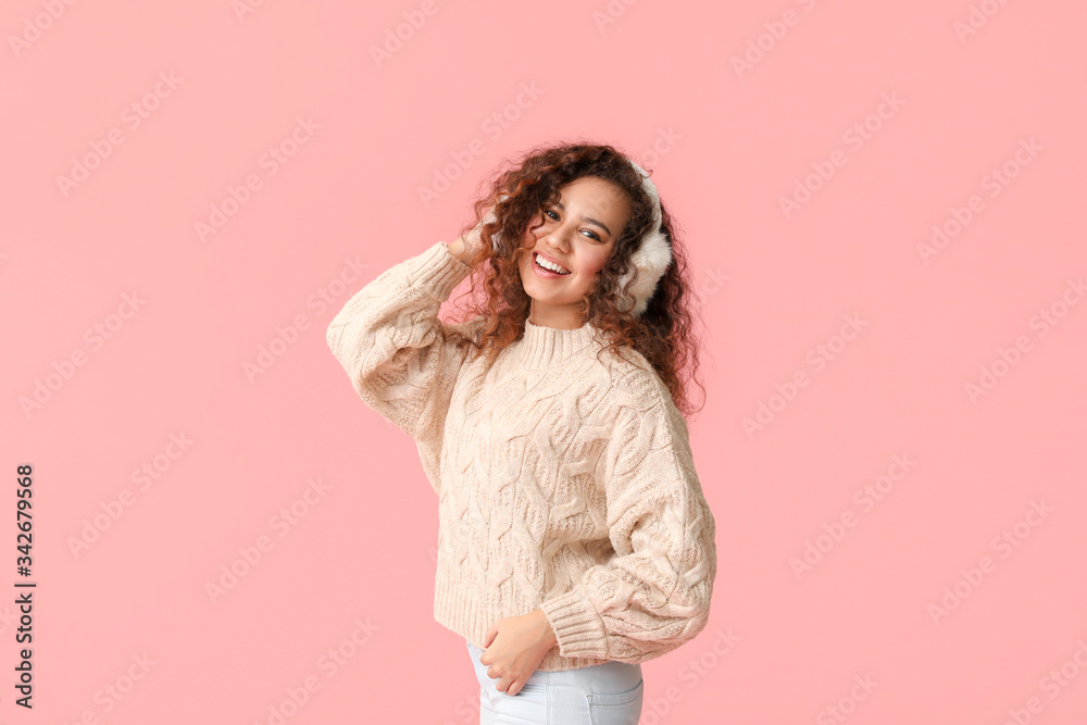 Young woman in warm sweater on color background