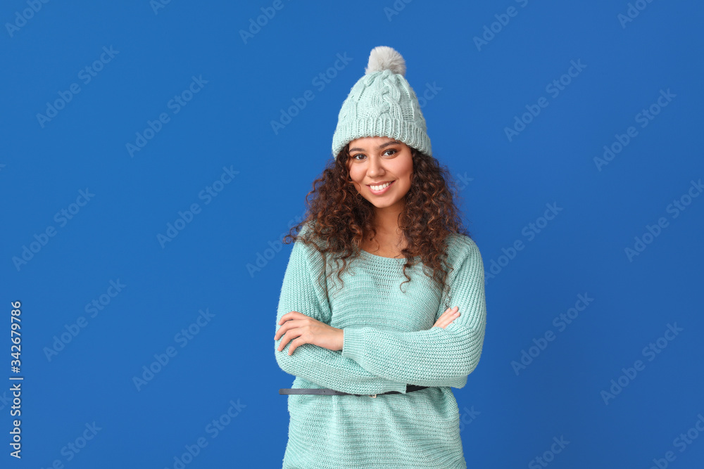 Young woman in warm sweater on color background