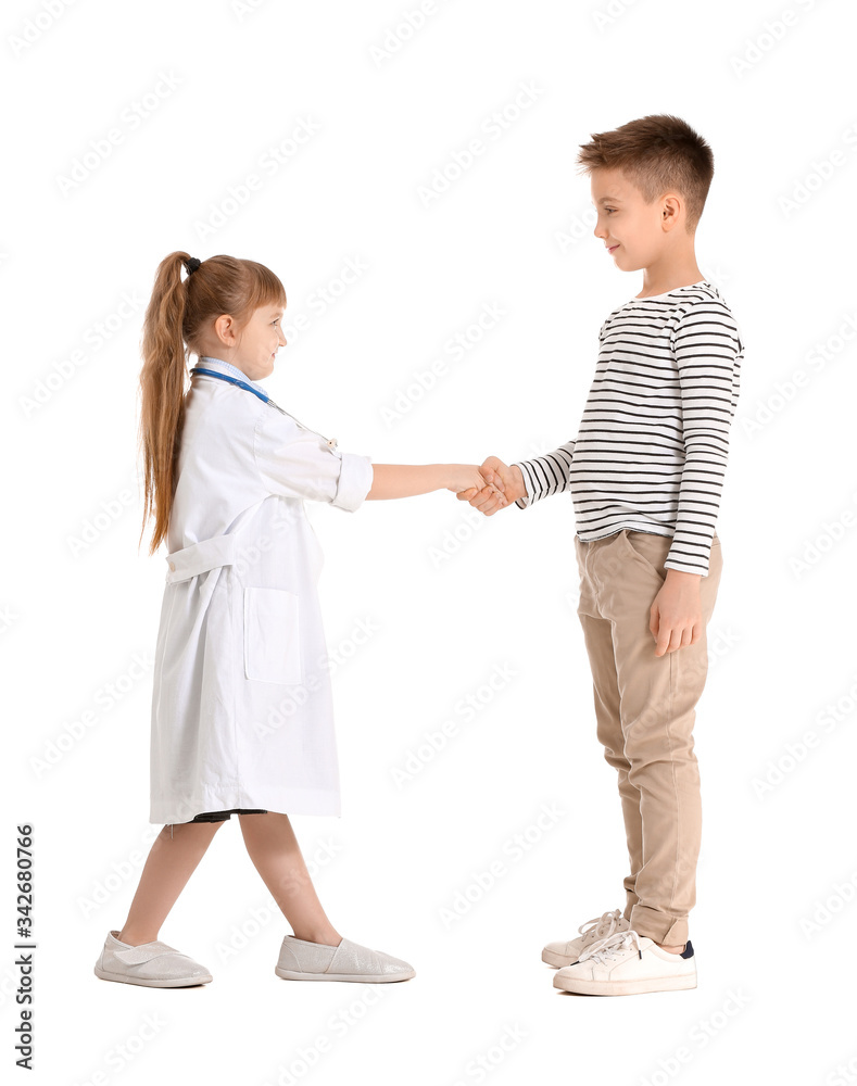 Cute little doctor with patient shaking hands on white background