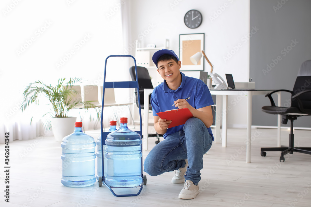 Delivery man with bottles of water in office