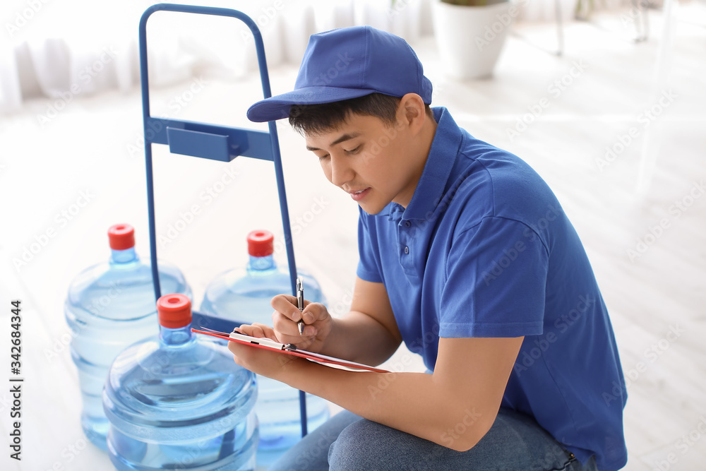 Delivery man with bottles of water in office