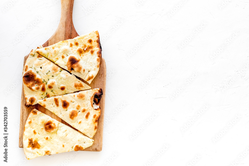 Make focaccia. Traditional italian bread on cutting board on white table top-down copy space