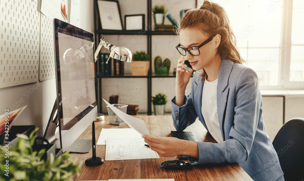 Young woman discussing document during phone conversation.