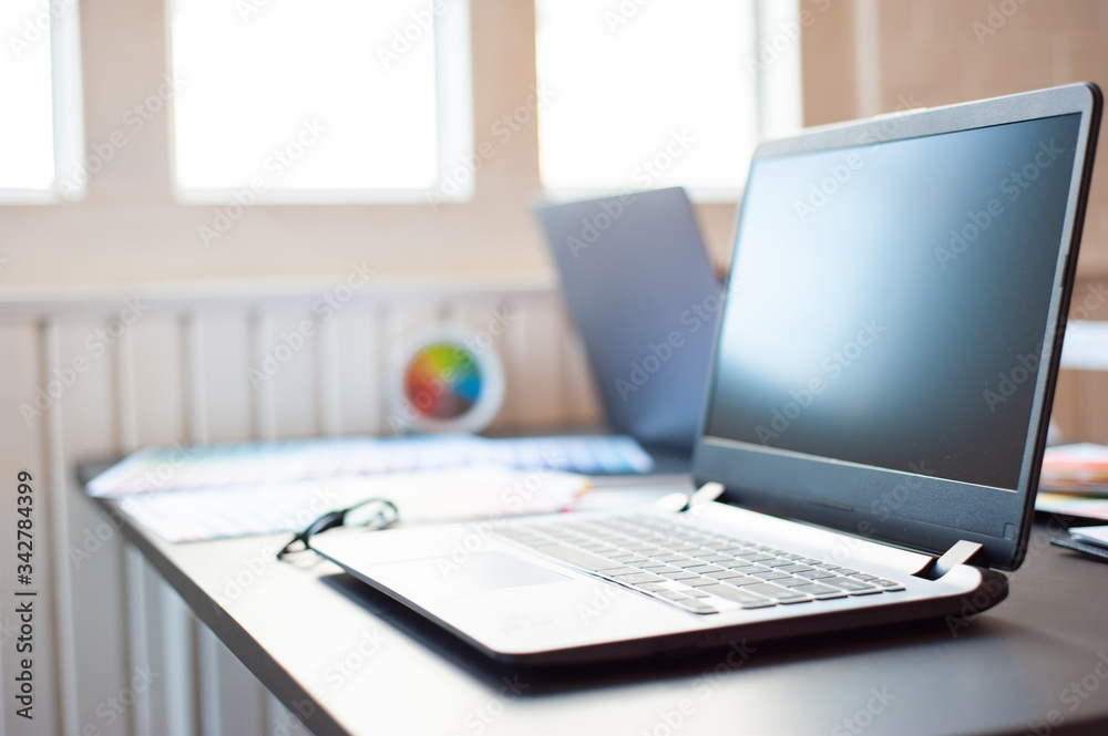 Office desks with laptops and work equipment.