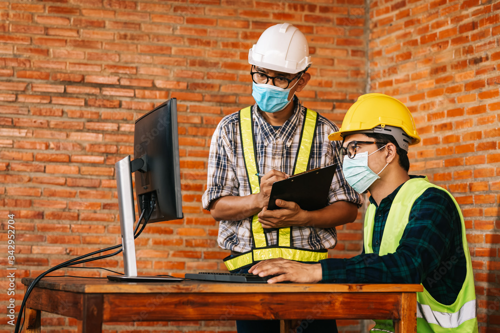 Construction concept of Engineer and Architect are to wear medical masks working at Construction Sit