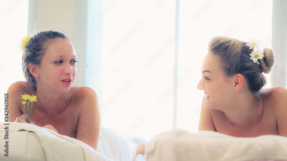 Two women at massage room having conversation in luxury day spa. Wellness, leisure and healthcare co