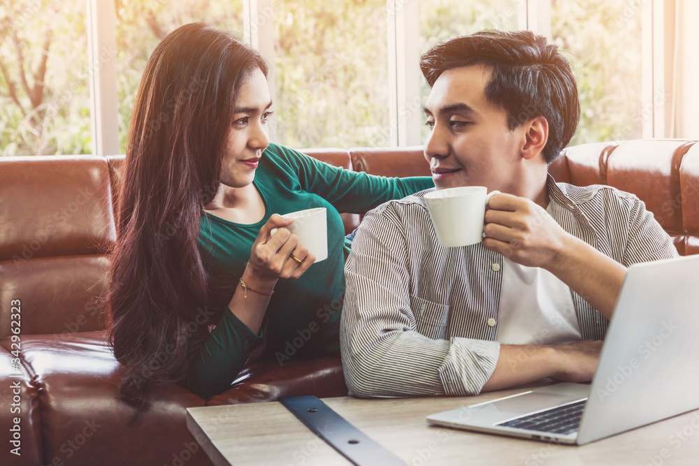 Happy Asian couple drink coffee at home. Love relationship and lifestyle concept.