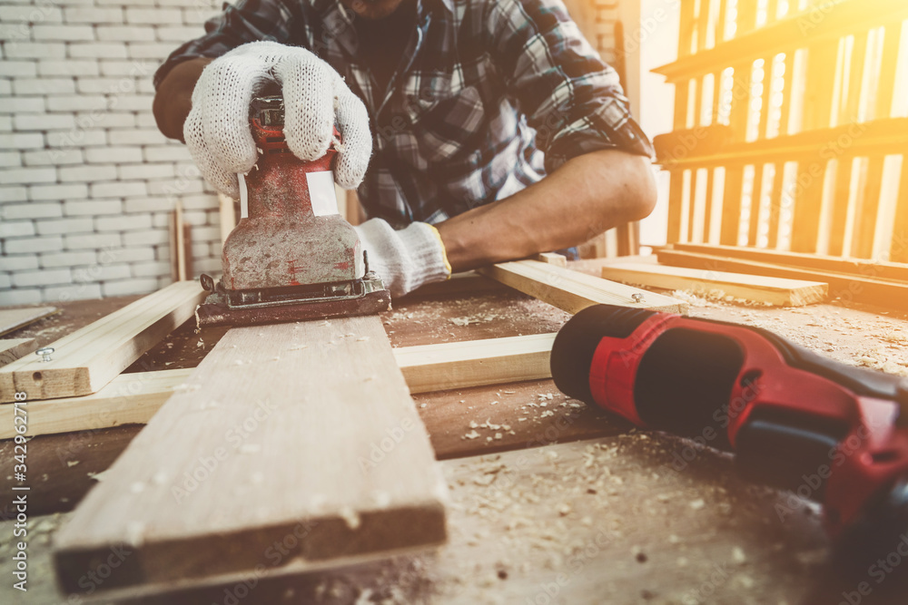 Carpenter working on wood craft at workshop to produce construction material or wooden furniture. Th