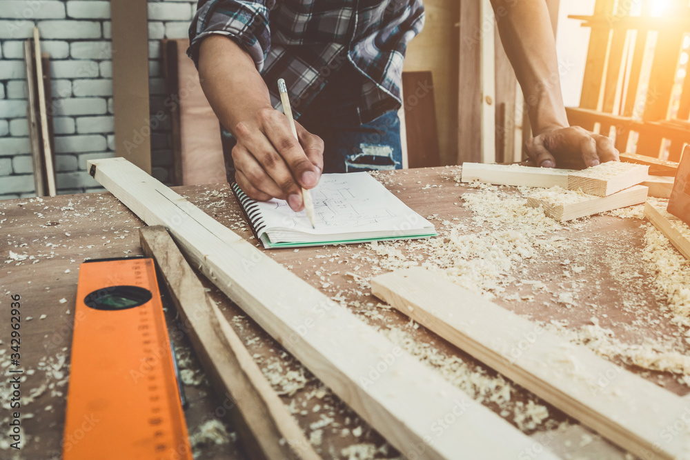 Carpenter working on wood craft at workshop to produce construction material or wooden furniture. Th