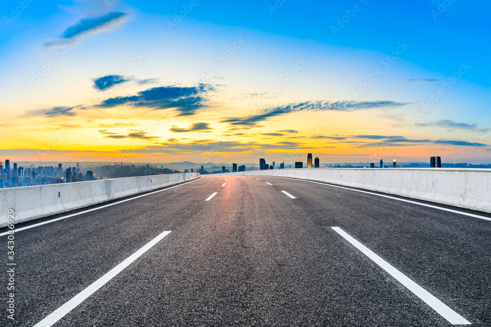 Empty asphalt road and Chongqing city skyline and buildings at sunset,China.