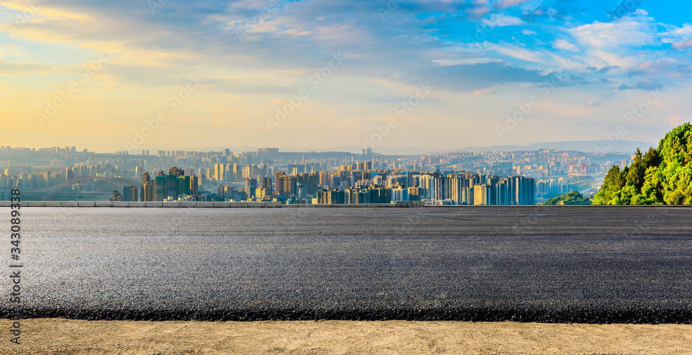 空旷的柏油路，日落时的重庆城市天际线和建筑，中国。