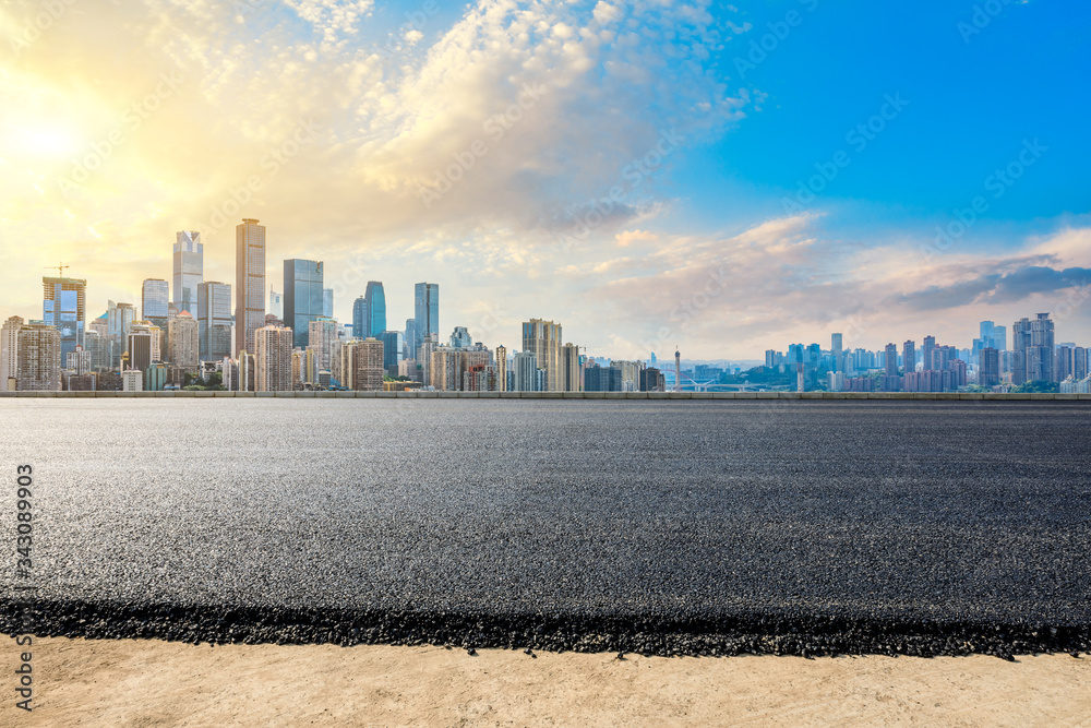 空旷的柏油路，日落时的重庆城市天际线和建筑，中国。