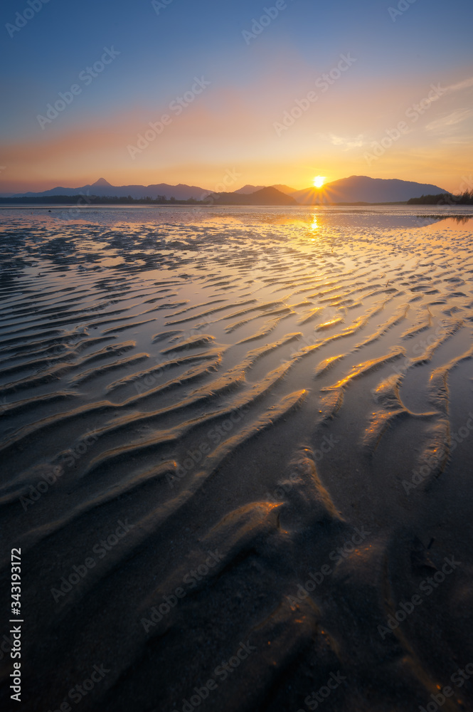 Beautiful sunrise view of low tide beach sand texture show up in morning