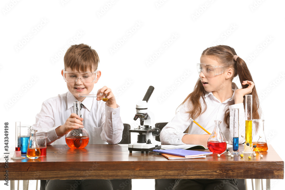 Cute little children studying chemistry at table against white background