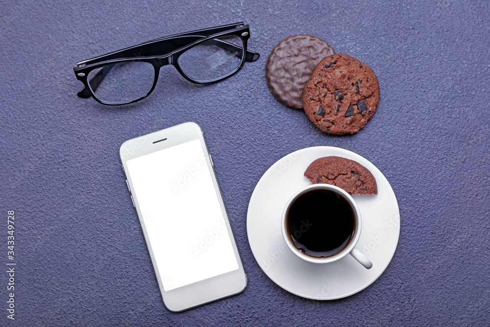 Cup of coffee with cookies, eyeglasses and mobile phone on dark background