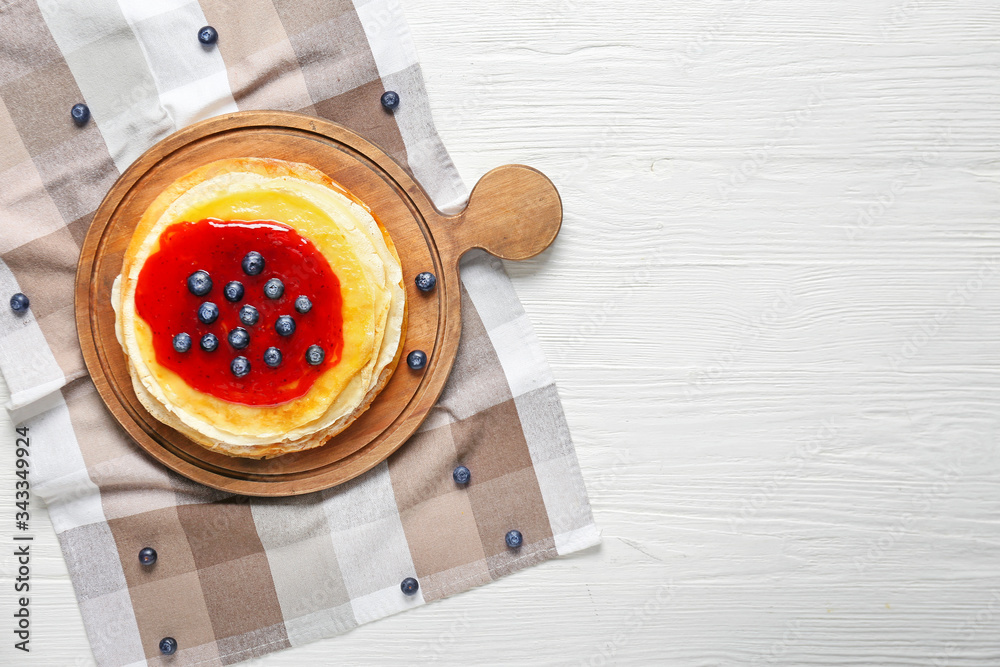 Tasty blini with berries on table