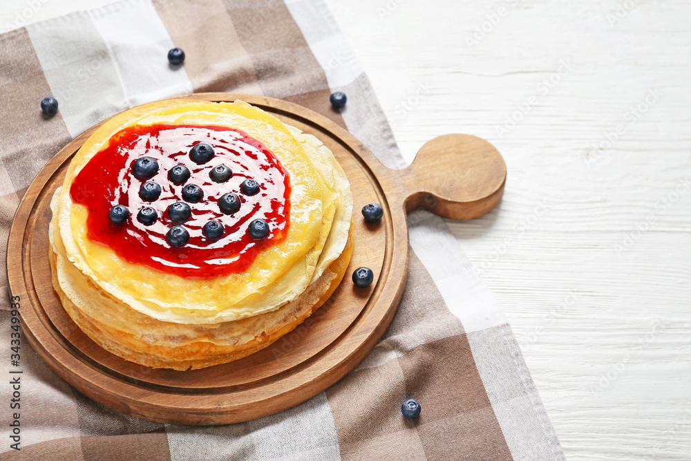 Tasty blini with berries on table