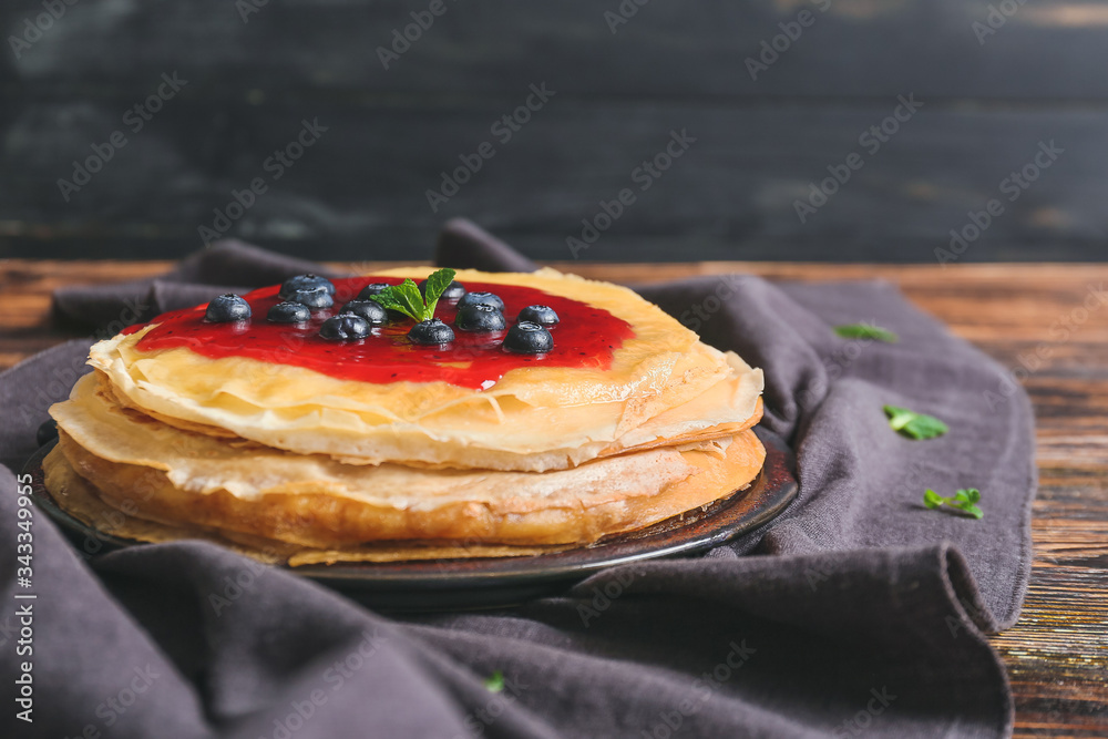 Tasty blini with berries on table