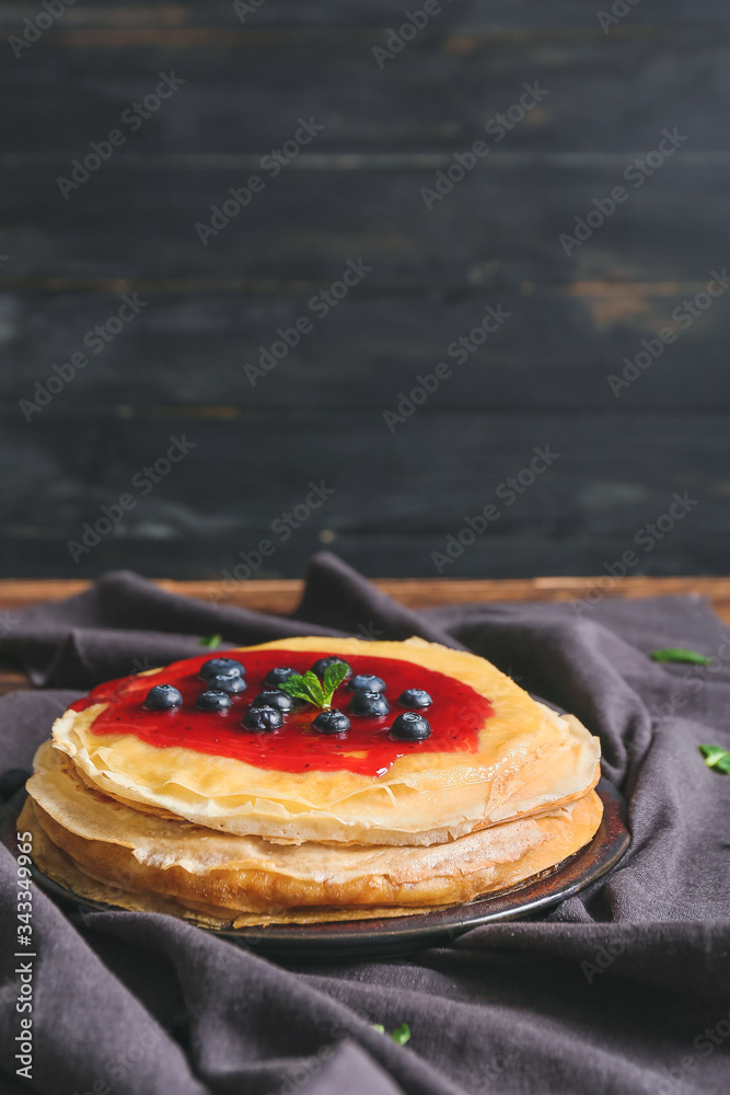 Tasty blini with berries on table