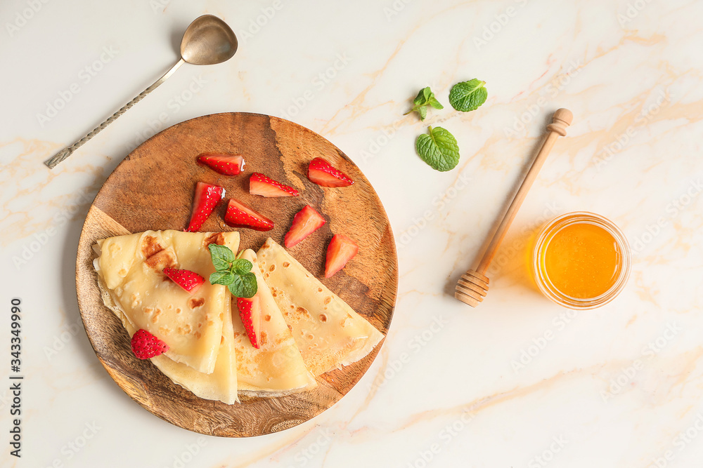 Tasty blini with berries and honey on table