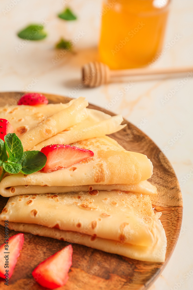 Plate with tasty blini and berries on table, closeup