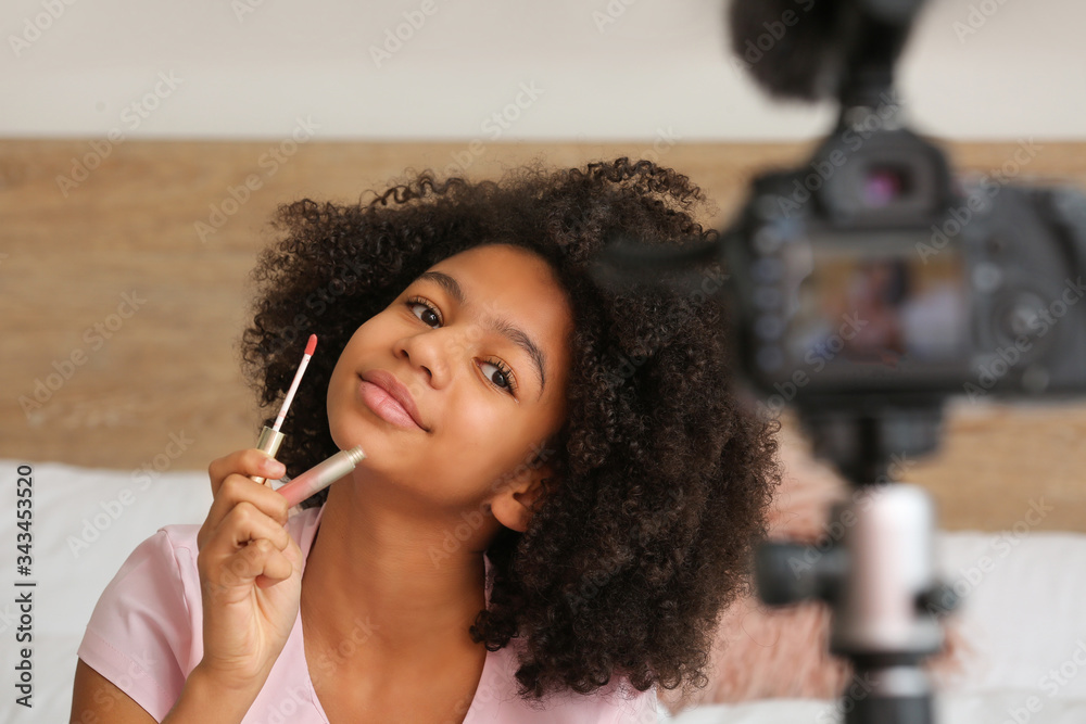 African-American teenage fashion blogger recording video at home