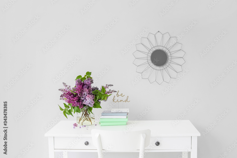 Vase with beautiful lilac flowers on table in room