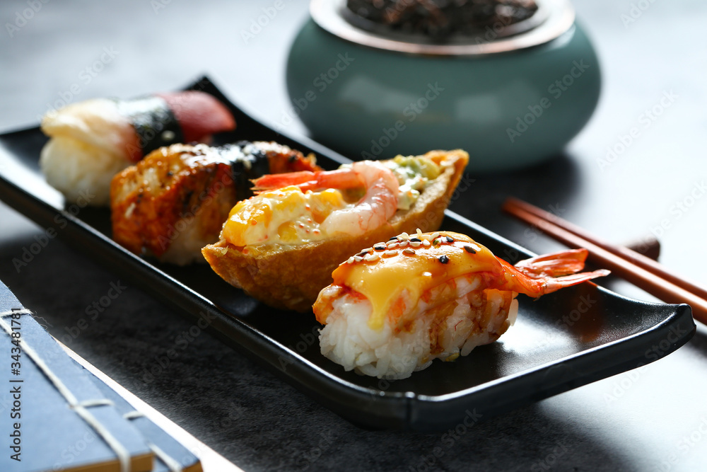 Japanese sushi in black plate on dark background