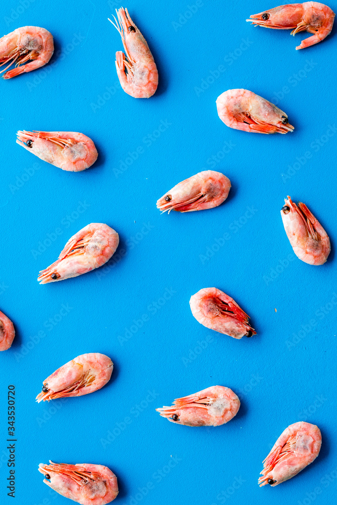 Shrimps - frozen - pattern on blue background top view