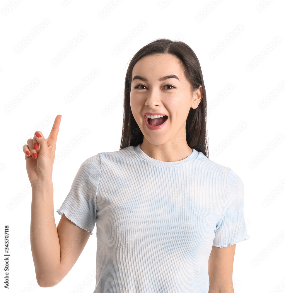 Portrait of beautiful young woman with raised index finger on white background