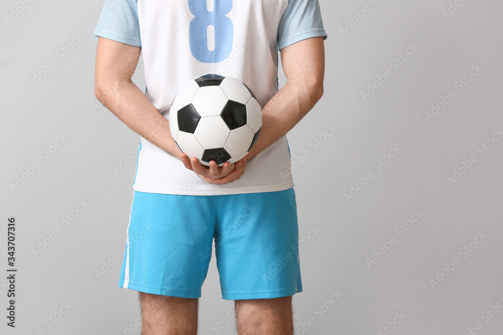 Male football player on grey background