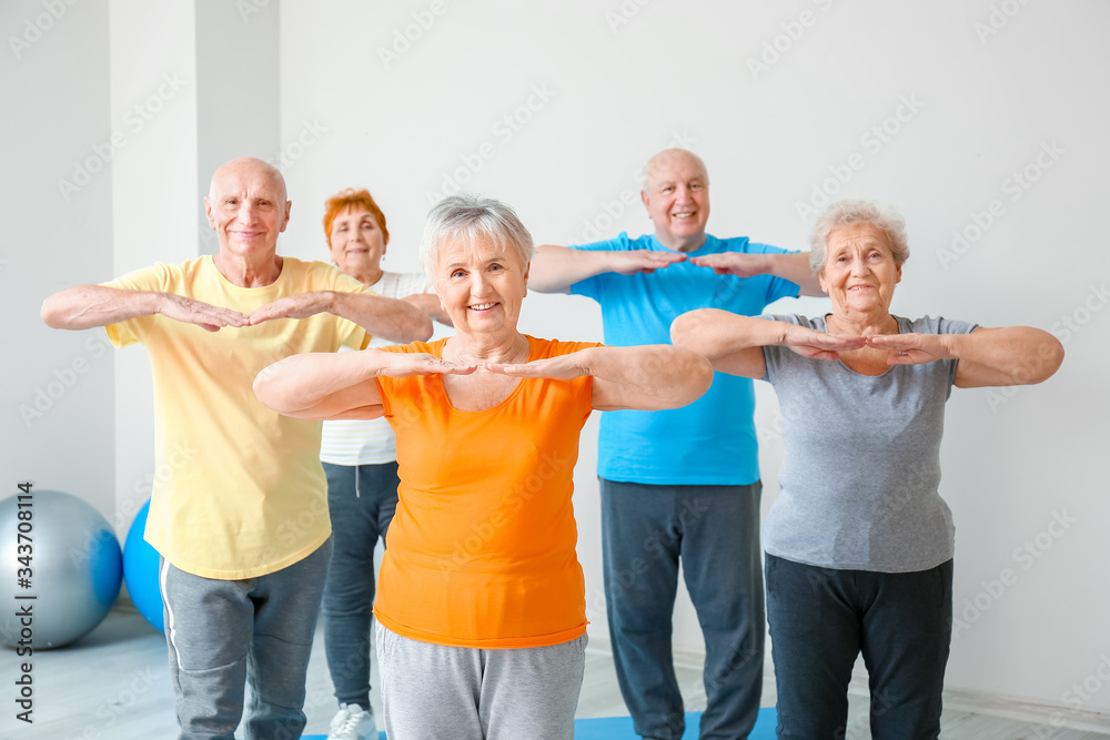 Elderly people exercising in gym