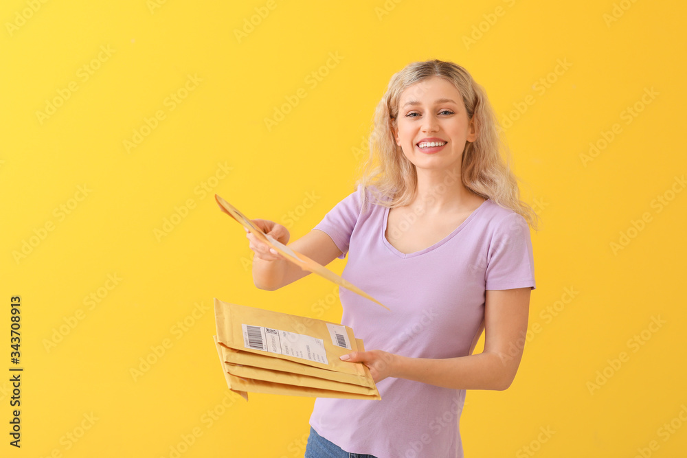 Young woman with letters on color background