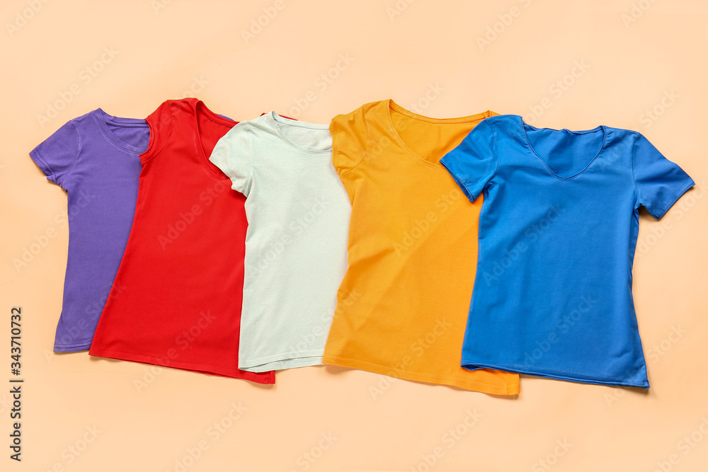 Stylish t-shirts on color background